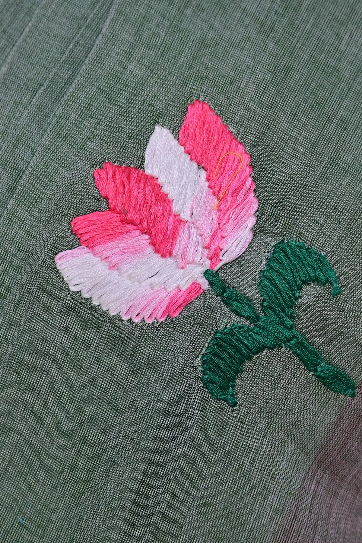 Sage green cotton saree with pink lotus embroidery, close-up