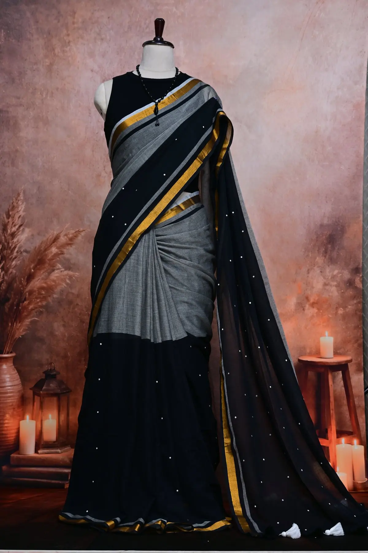 Grey cotton pleats under a black pallu with small silver dots and a gold and grey striped border.