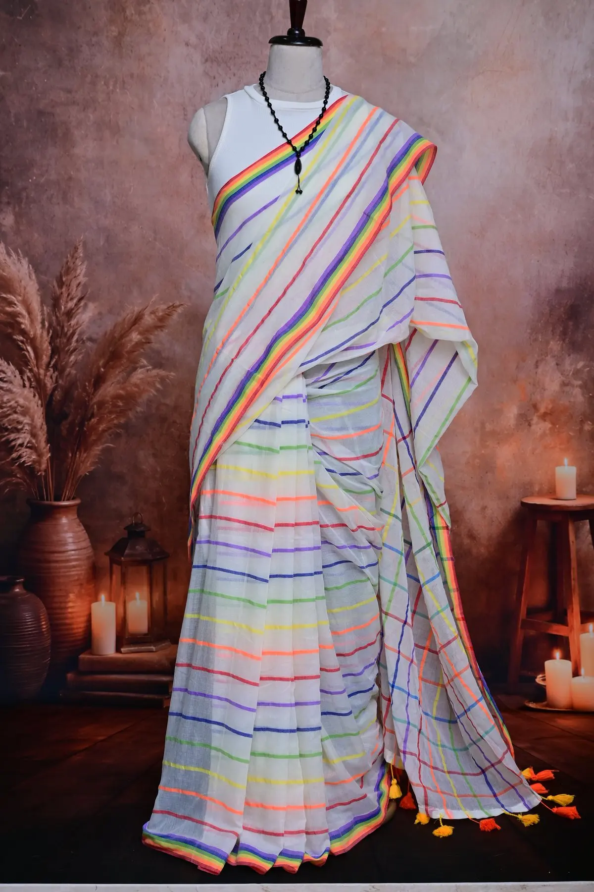 White cotton saree pleats with thin rainbow stripes and a rainbow border at the hem.