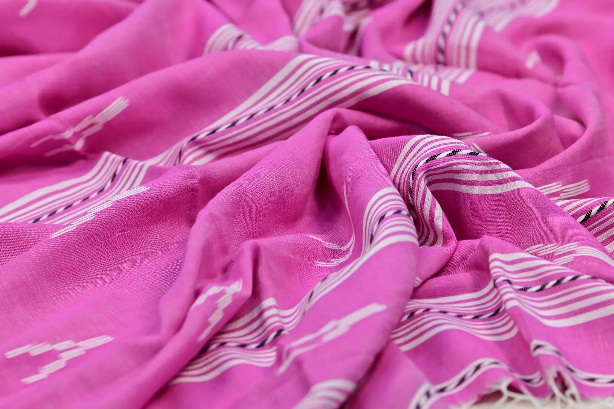 Pink cotton saree with white stripes and tassels, texture