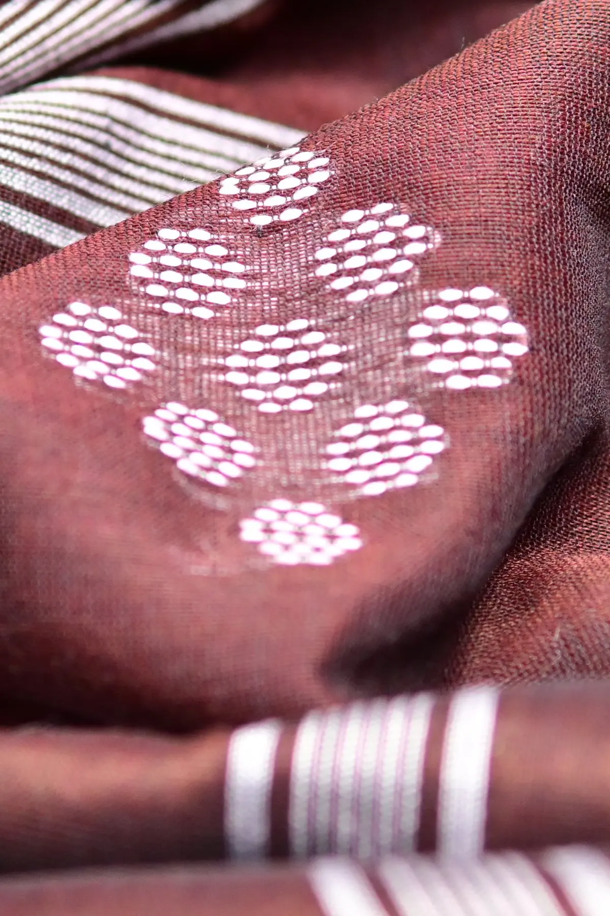 Maroon cotton saree with white dot clusters, close-up