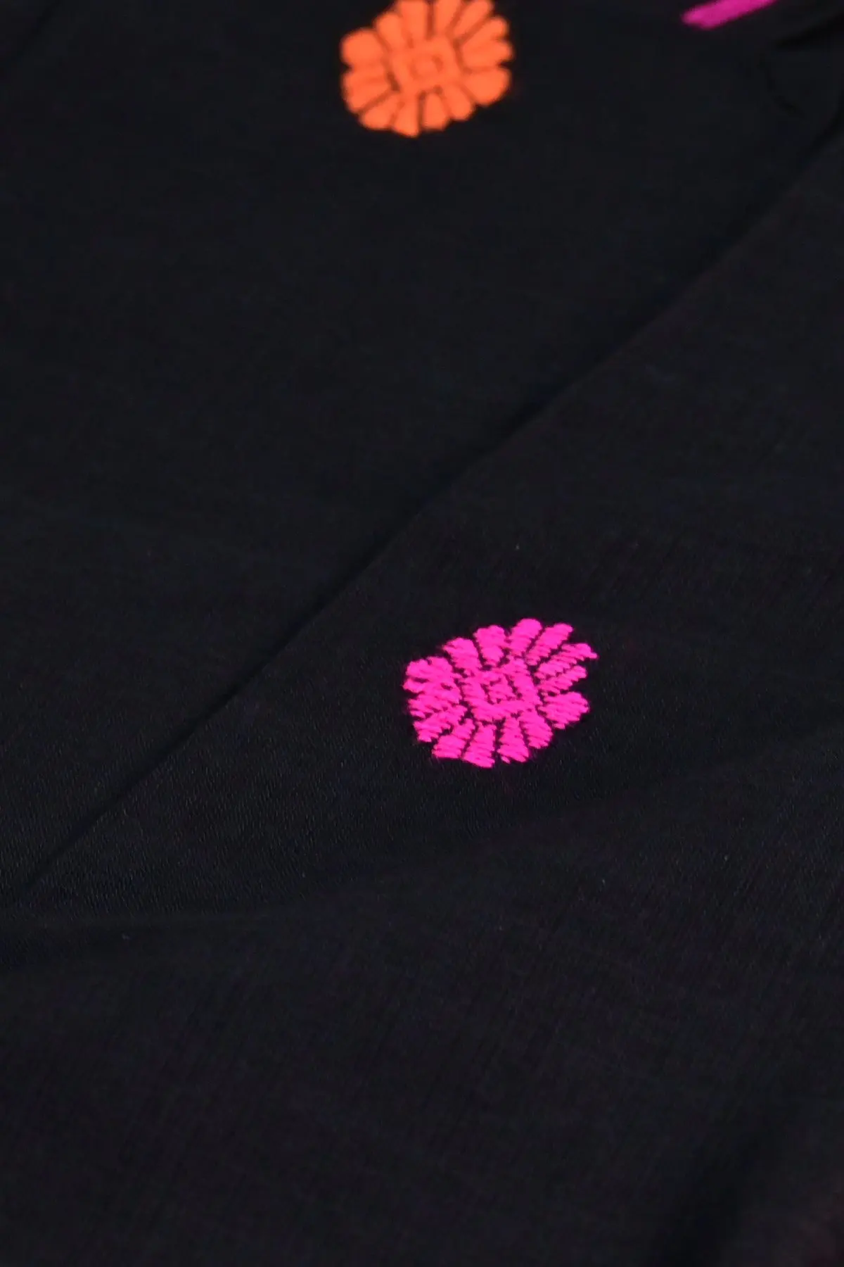 Black cotton saree with pink geometric pallu, close-up