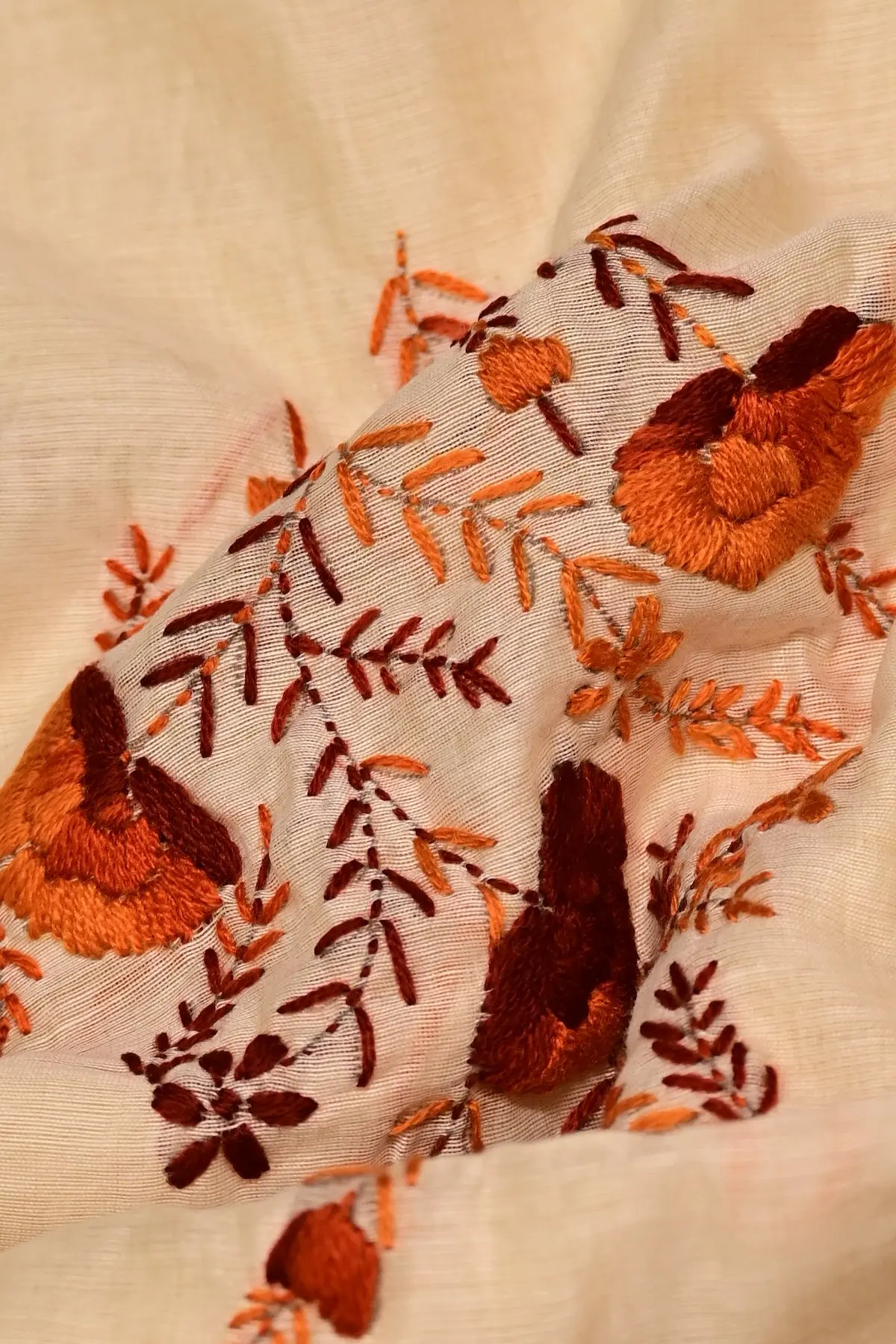 Cream saree with rust and maroon floral embroidery, close-up