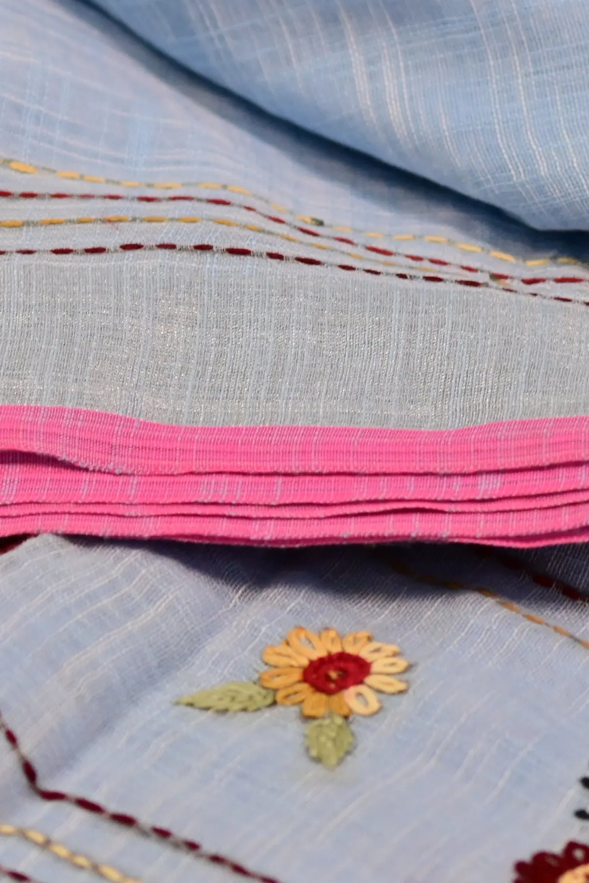 Pale blue linen saree with floral embroidery, border
