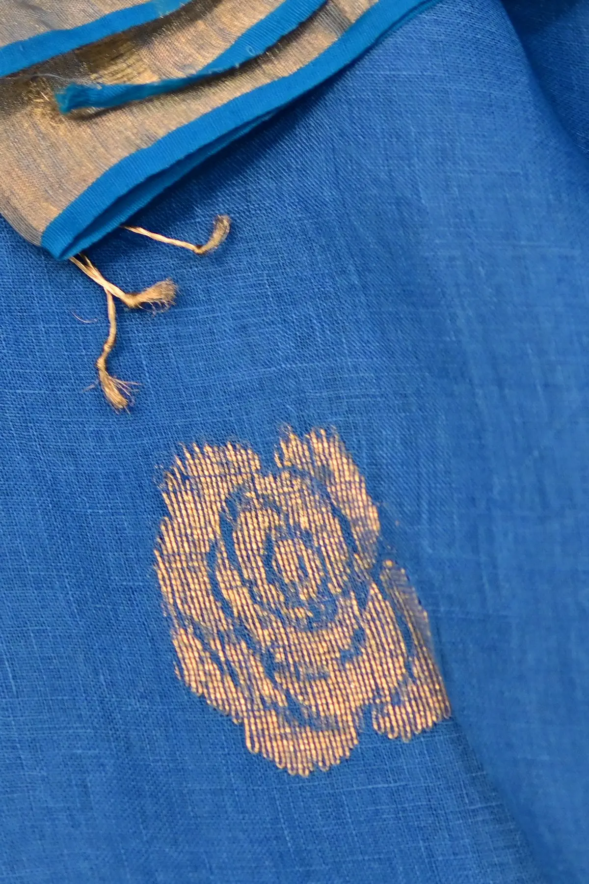 Blue linen saree with gold rose motifs, close-up