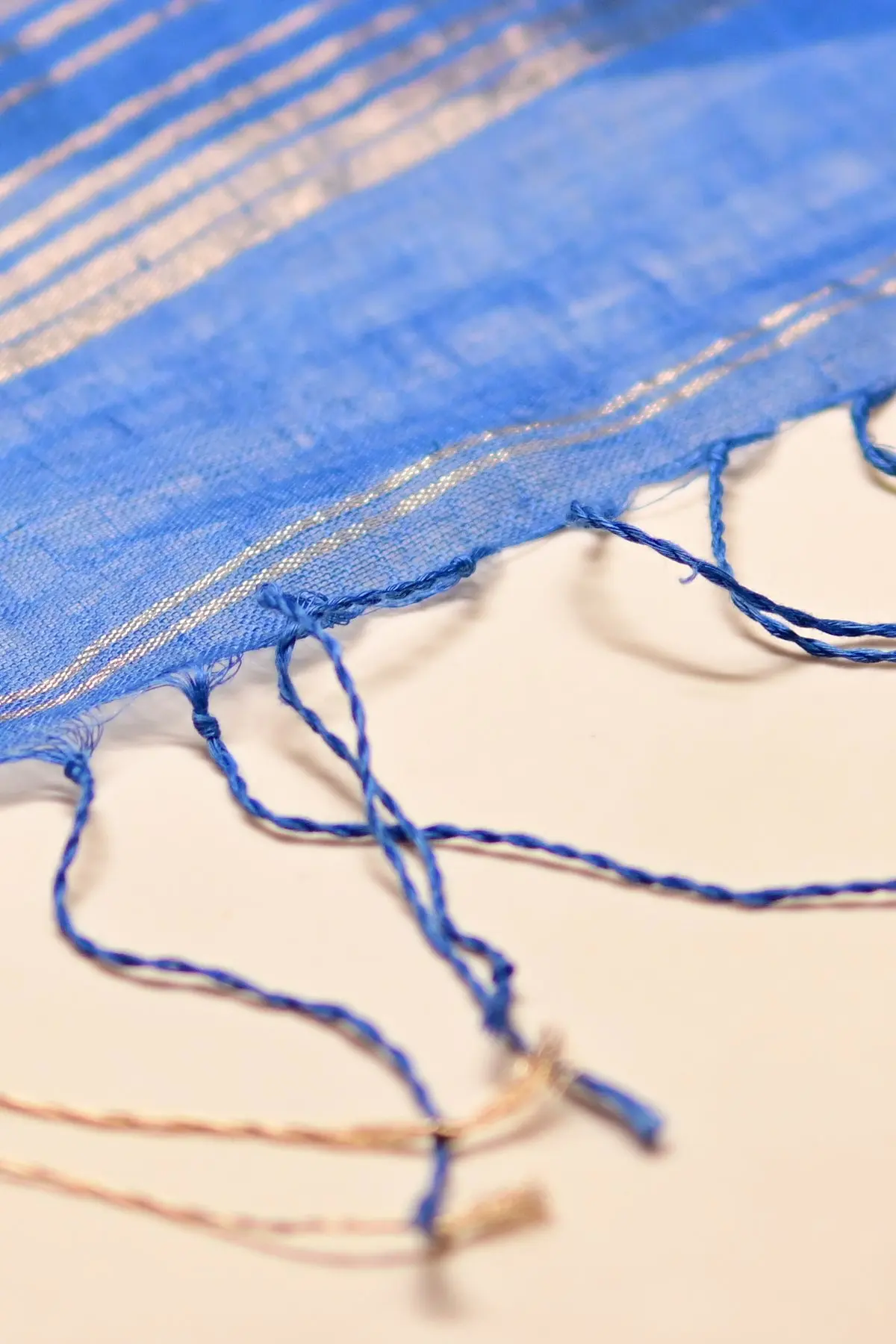 Blue linen saree with gold rose motifs, tassels