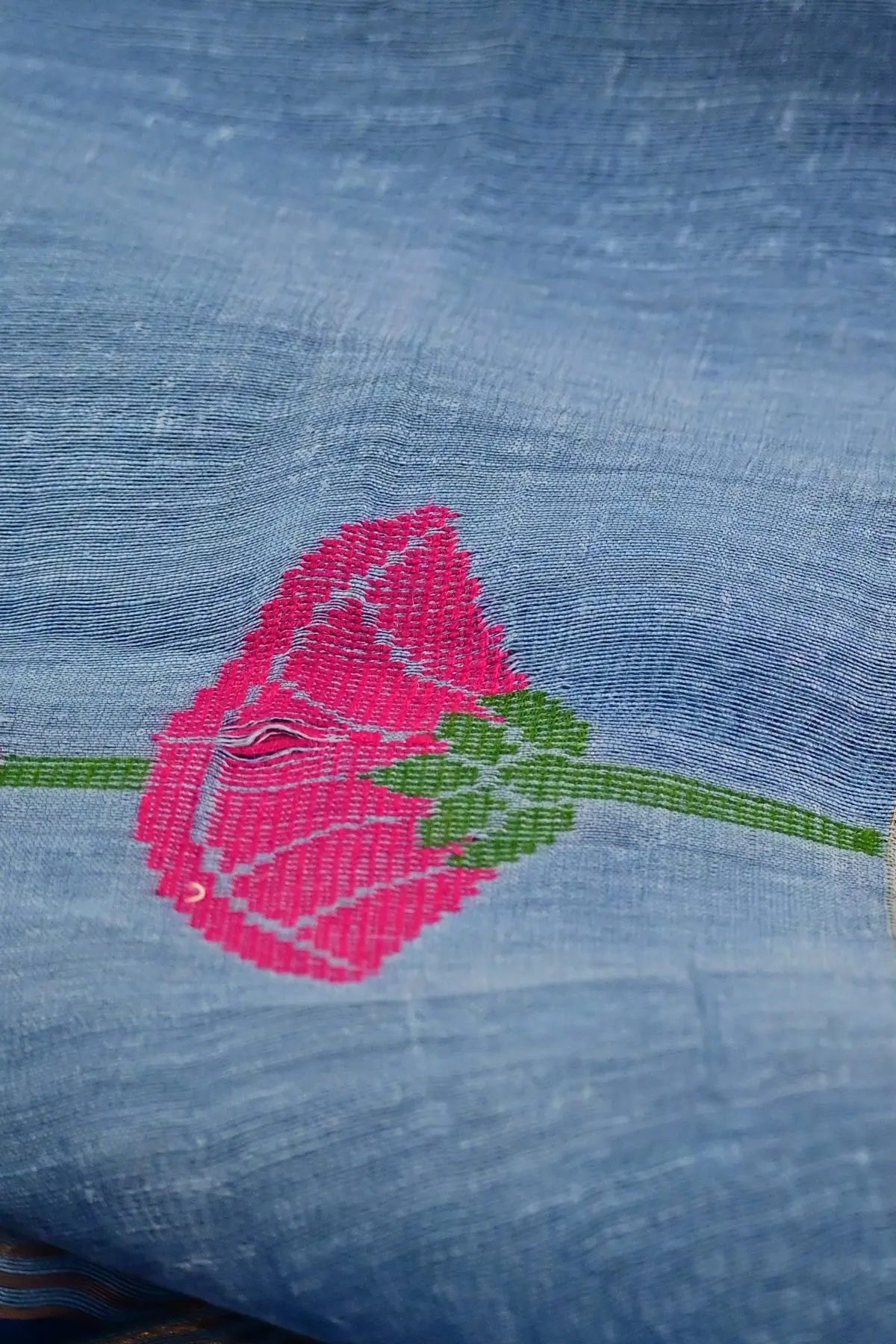 Light blue linen saree with lotus and swan motifs, close-up